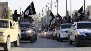 Militant Islamist fighters parade on military vehicles along the streets of northern Raqqa province