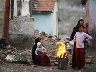 Syrian refugees warm themselves around a fire in Hacibayram district of Ankara