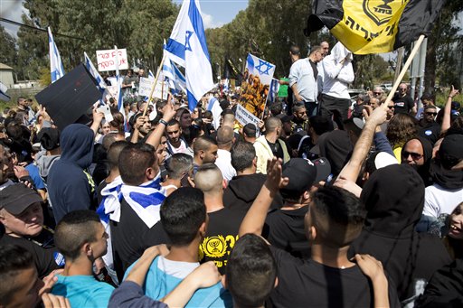 Israeli right wing protesters wave flags outside of Castina military court