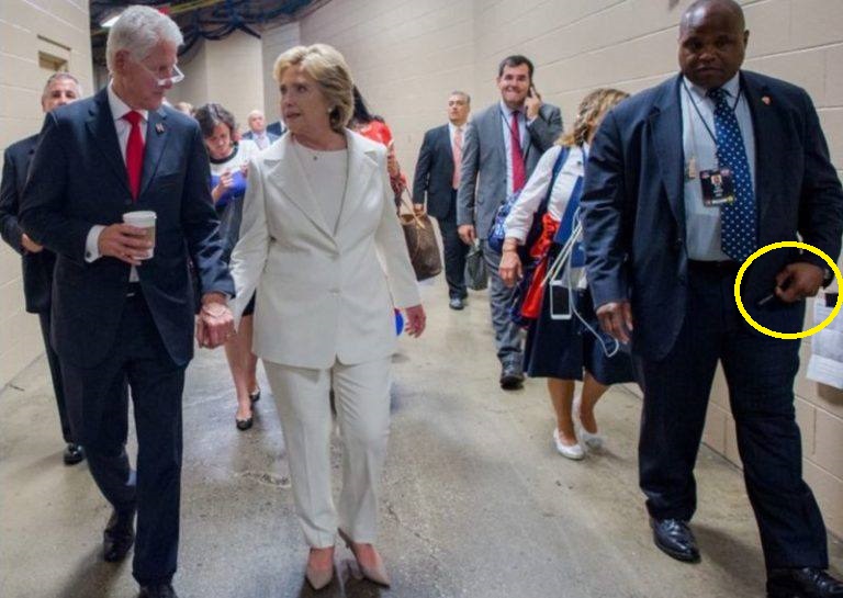 Evidence has emerged that Hillary’s handler - a man who carries what looks like a medical lapel-pin - always has an auto-injector syringe with Diazepam on hand.