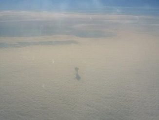 Airplane passenger captures weird humanoid creature walking across a cloud
