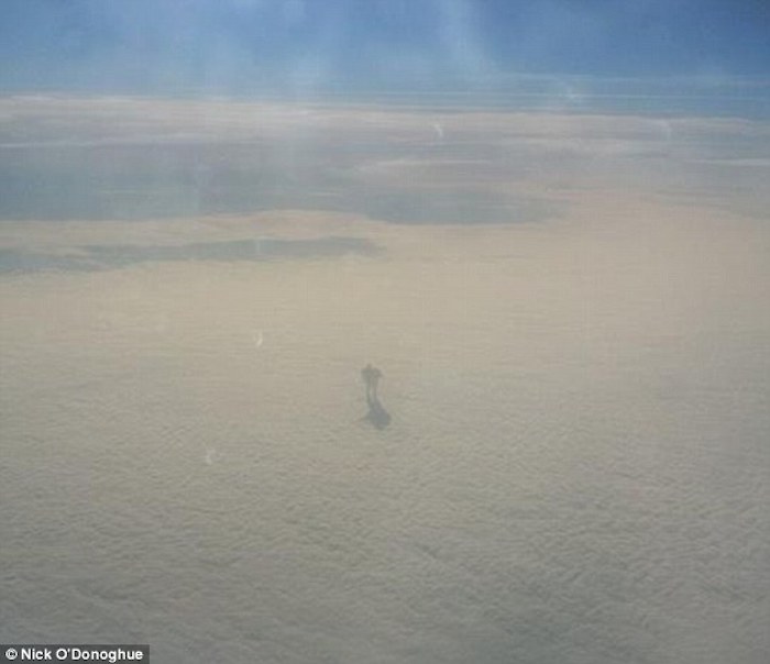 Airplane passenger captures weird humanoid creature walking across a cloud