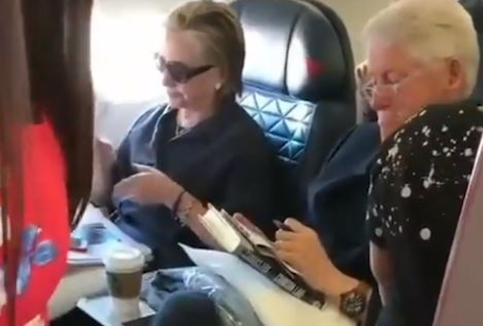 Clintons caught flying commercial, reading book about child rape