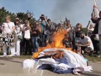 Fired New York healthcare workers burn their scrubs in protest to vaccine mandates
