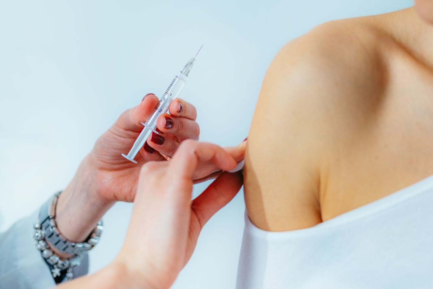 female-doctor-injecting-syringe-on-woman